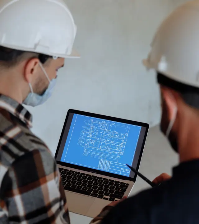 Engineers reviewing project plans on a laptop